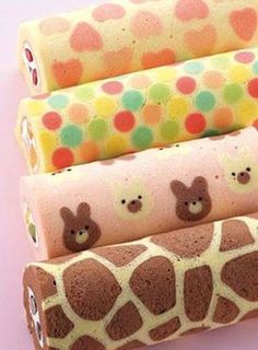 four rolls of toilet paper with giraffes and polka dot designs on them