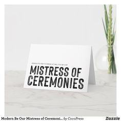 a card that says, master of ceremonies? on it next to a plant