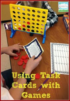 two children are playing with games on the table and one child is holding a game board