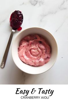 a white bowl filled with cranberry aioli next to a spoon on top of a marble counter