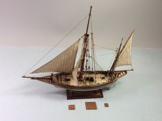 a model sailboat on a wooden stand