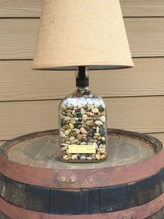 a lamp that is sitting on top of a barrel with rocks and gravel in it