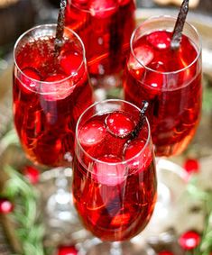 three glasses filled with red liquid on top of a plate