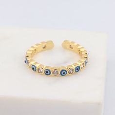 Gold Evil Eye Promise Ring, Blue Jeweled Rings For Gifts, Blue Jeweled Rings For Gift, Gold Evil Eye Open Ring, Gold Open Ring With Evil Eye, Gold Open Ring With Evil Eye Detail, Gold Jeweled Promise Ring, Gold Jeweled Open Crystal Ring, Gold Jeweled Crystal Open Ring