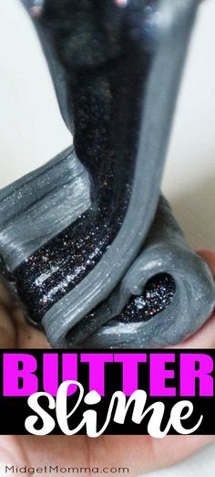 a hand holding a black and silver object with glitter on it that says butter slime