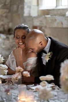 a bride and groom are cutting their wedding cake at the reception table with candles in front of them