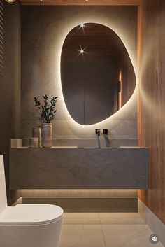 a bathroom with a round mirror above the sink and a white toilet next to it