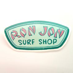 an iron - on surf shop sticker with the word ron jon written in pink and green