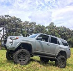 a gray truck parked on top of a lush green field