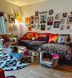 a living room filled with lots of furniture and pictures on the wall above it's windows