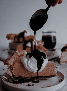 a piece of pie is being drizzled with chocolate sauce and whipped cream