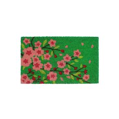 a green door mat with pink flowers on it