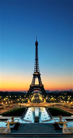 the eiffel tower is lit up at night