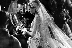 the bride and groom are looking at their cell phone in this black and white photo