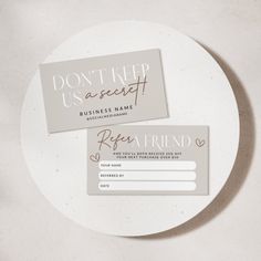 two business cards sitting on top of a white plate with the words don't keep us