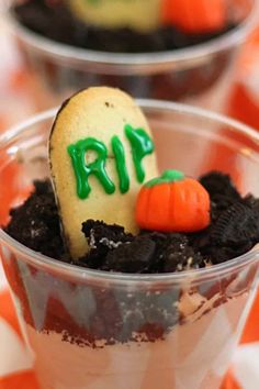 two desserts in plastic cups with halloween decorations