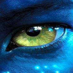 an eye with glowing blue and yellow colors is shown in this close up photo from the movie avatar