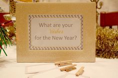 wooden clothes pins sitting on top of a table next to a sign that says, what are your wishes for the new year?