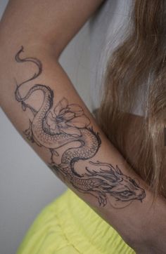 a woman with a dragon tattoo on her arm