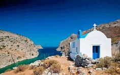 a small white church on the side of a cliff