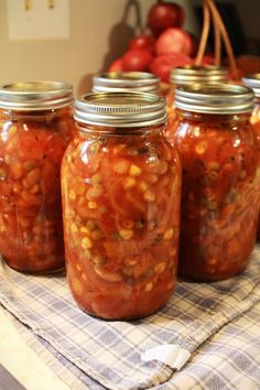 four jars filled with food sitting on top of a table