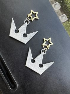 two silver and gold earrings with stars on them