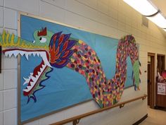 two colorful paintings hanging on the wall in a school hallway, one with a dragon and another with a bird