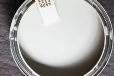 a close up of a white paint can with a tag on the top of it