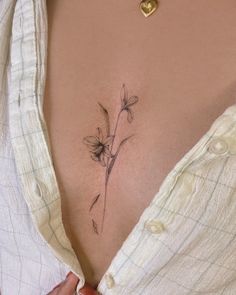 a woman's stomach with a small flower tattoo on her belly and the bottom part of her stomach