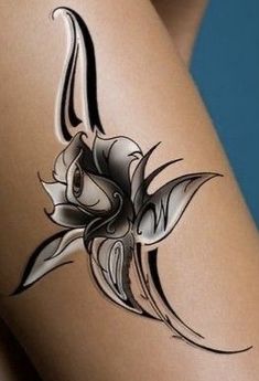 a woman's thigh with an artistic tattoo design on it