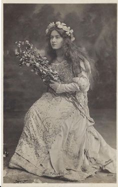 an old fashion photo of a woman with flowers in her hair, holding a bouquet