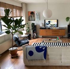 a living room filled with furniture and a flat screen tv sitting on top of a wooden floor