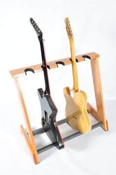 two guitars are hanging on a rack with hooks