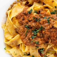 pasta with meat sauce and parsley in a white bowl