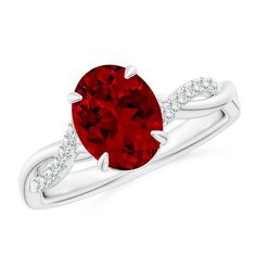 a ring with a large red stone and diamonds on the band, set in white gold