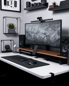 a desk with a computer and speakers on it