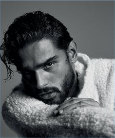 a man with a goatee is posing for a black and white photo wearing a sweater