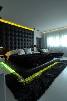 a black and white bedroom with neon lights on the headboard, rugs and bedding