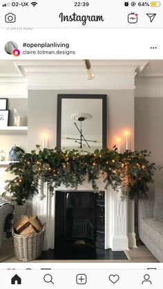 a living room decorated for christmas with candles on the mantle and greenery over the fire place