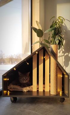 a cat sitting in a wooden house shaped like a dog house with lights on it