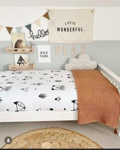 a child's bedroom with a bed, rug and wall hangings