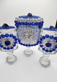 three glass vases with blue beads on them