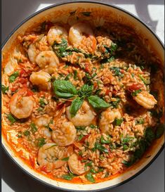 a pan filled with shrimp and rice on top of a table