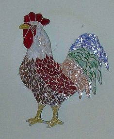 a glass rooster ornament hanging on a wall