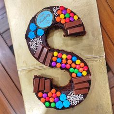 a cake shaped like the letter s with candy and candies on it's side