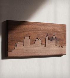 a wooden cityscape hanging on the wall