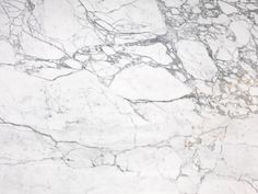 a white marble textured surface with grey veiners