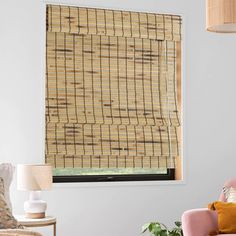 a living room with a pink chair and bamboo blinds