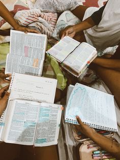 several people sitting on a bed with open books