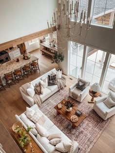 an aerial view of a living room with couches, tables and chandelier